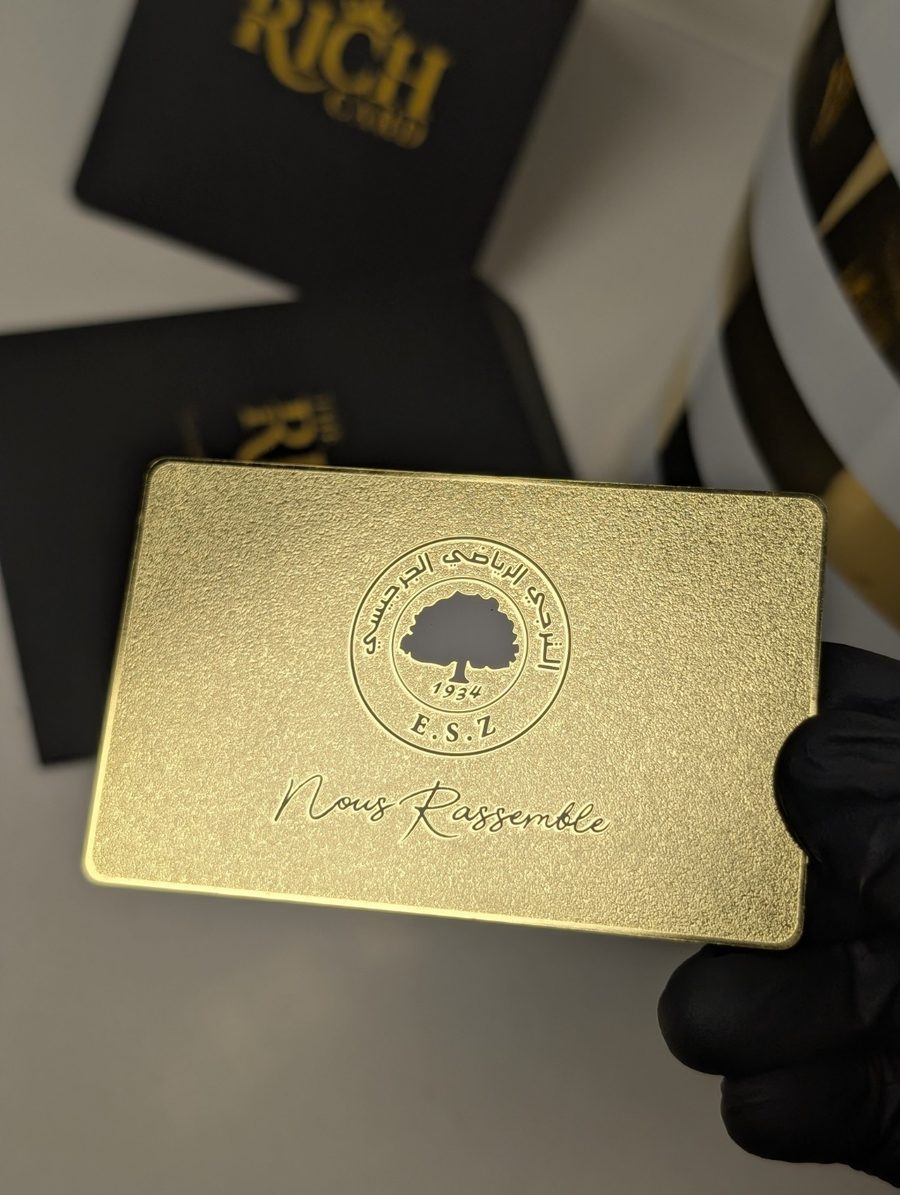 Textured gold-tone E.S.Z. metal membership card with club emblem