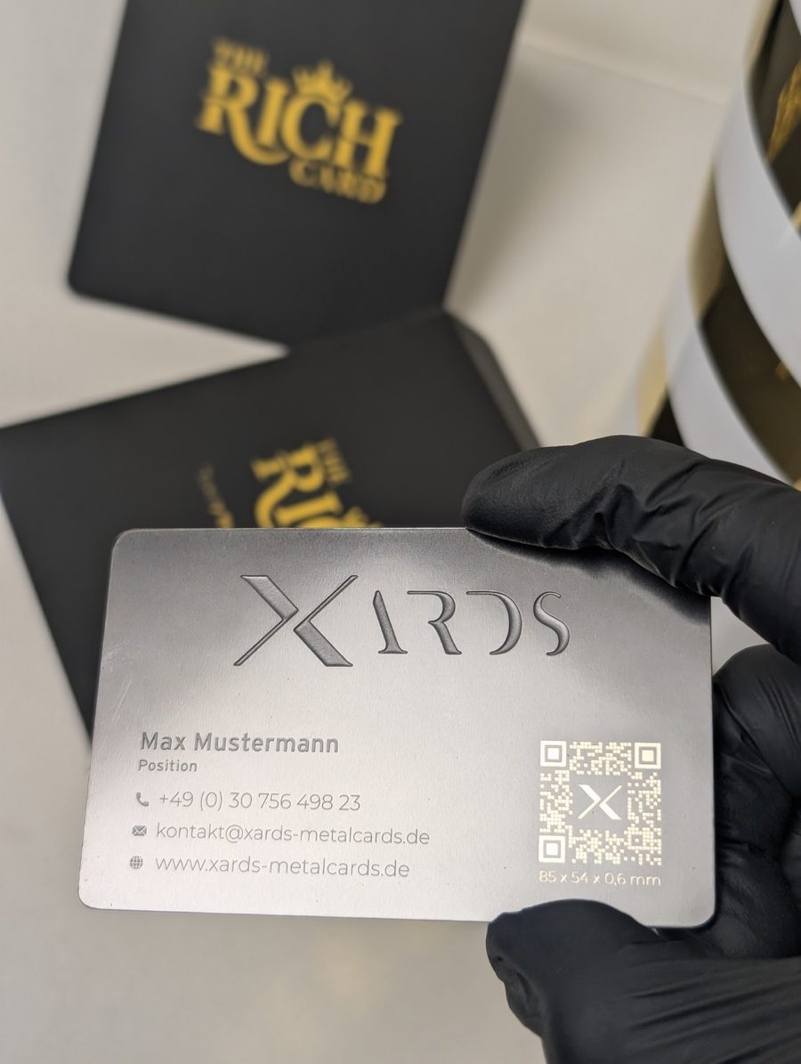 XARDS silver-tone metal business card with printed contact details and QR artwork